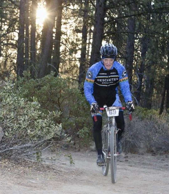 Dr. Tad Hodgert racing a cyclocross course through the pines in Central Oregon.