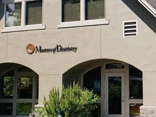 The swan sign on the gable of the Masters of Dentistry building, above two arched windows.